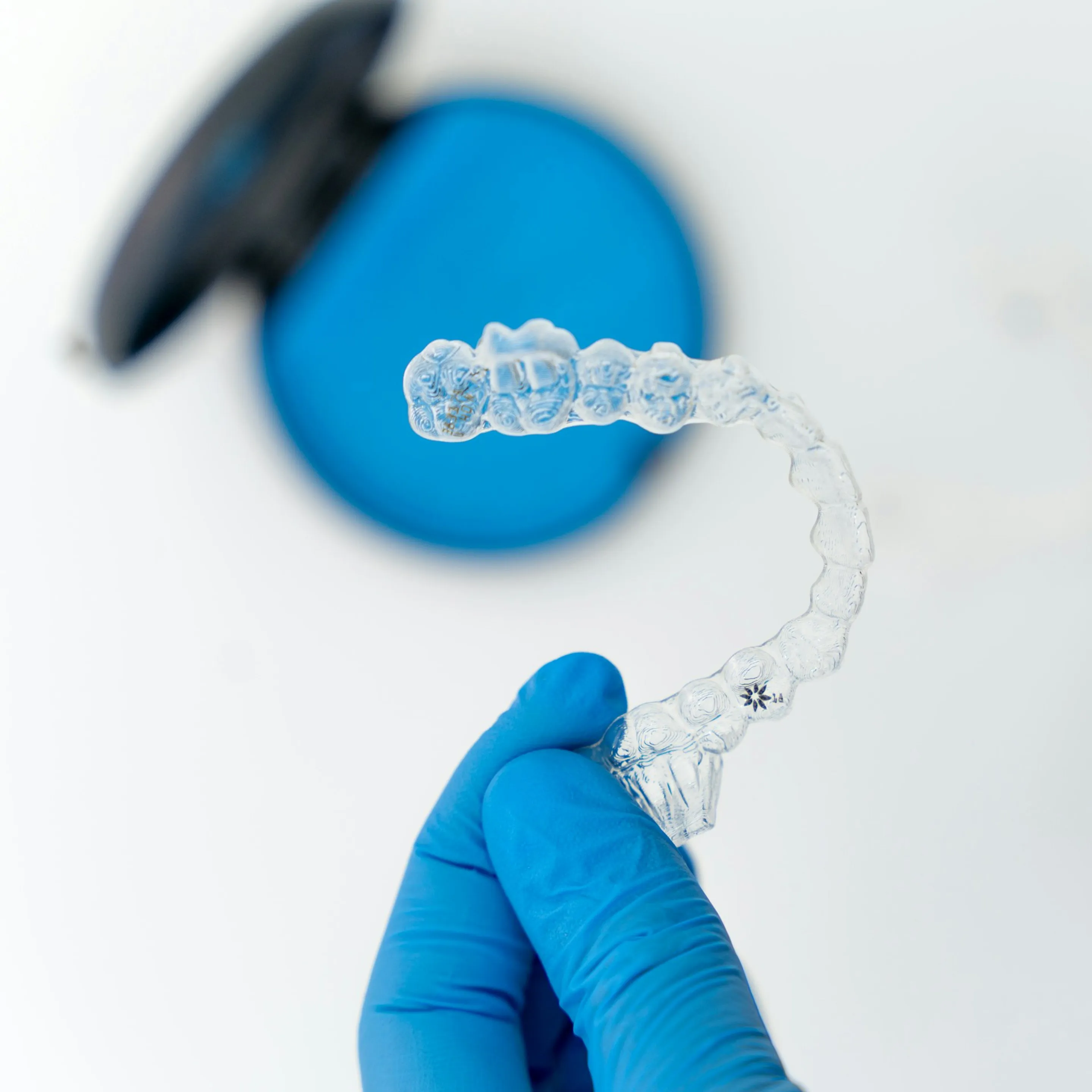 Transparente Aligner-Schiene wird mit behandschuhter Hand gehalten